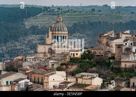 Panoramablick auf die St. George Kathedrale und die UNESCO-Weltkulturerbestätte Ragusa Ibla, Sizilien, Italien, mit terrassenförmig angelegten Hügeln im Hintergrund Stockfoto