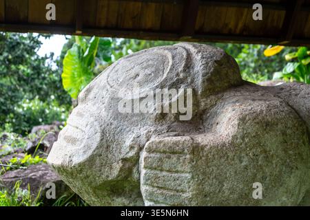 Alte Steinschnitzerei einer gebärenden Frau in Te Lipona in Puamau, Hiva OA, Französisch-Polynesien. Dieses heilige marquesanische Artefakt symbolisiert Fruchtbarkeit und l Stockfoto