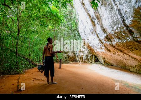 Ein Mann erkundet die üppige Dschungelhöhle in thailand Stockfoto