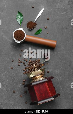 Kaffeemühle und Portafilter mit Kaffeepulver auf dunklem Hintergrund Stockfoto