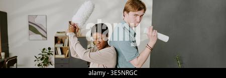Schwarze Frau und Mann, die das Haus für den Haushaltsdienst reinigen Stockfoto