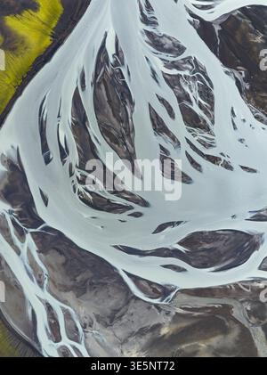 Aus der Vogelperspektive ziehen sich Gletscherflüsse durch die vulkanische Landschaft und erzeugen einen faszinierenden Tanz aus weiß auf der dunklen Erde, Highlands, Island Stockfoto