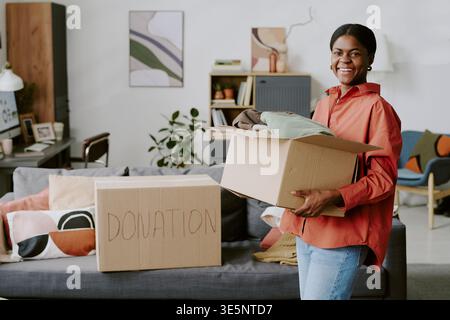 Porträt der Schwarzen Frau, die Spendenbox für Charity Drive hält Stockfoto