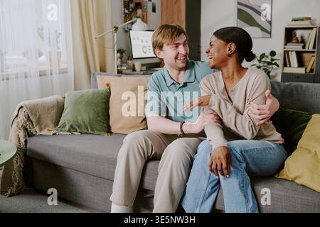 Erwachsener Mann und Schwarze Frau lachen zu Hause zusammen Stockfoto
