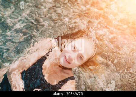 Frau schwimmt Wasser im Meer auf ihrem Rücken unter der warmen Sonne und genießt Sommerurlaub Stockfoto