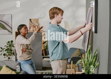 Erwachsenes Paar Hängende Wandbilder Beim Dekorieren Des Innenraums Stockfoto