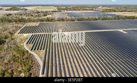 Aus der Vogelperspektive eines riesigen Solarparks, der sich unter klarem Himmel über die Landschaft erstreckt, Elkton, Florida, USA. Stockfoto