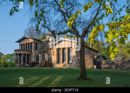 Holmwood House, eine historische viktorianische Steinvilla in Glasgow, liegt auf einem grünen Rasen unter alten Bäumen. Sonnendurchflutete Fassade, große Fenster und angelegte Gr Stockfoto