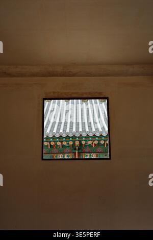 Dachfliesen des Korean Palace und Dancheong gemalte Dachschaufeln, die durch die quadratische Wand im Changdeokgung Palace in Seoul, Südkorea, gesehen werden Stockfoto