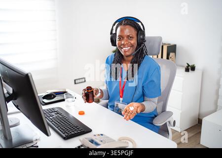 Weibliche Gesundheitsfachkraft, die virtuelle Unterstützung bietet, während sie Medikamente hält Stockfoto