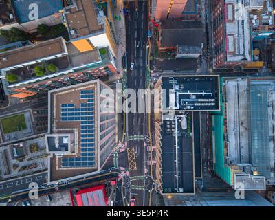Ein Blick von oben auf die Rochdale Road bei Sonnenaufgang, der den Kontrast zwischen modernen orangen Fassaden und dunklem Asphalt im Zentrum von Manchester zeigt. Stockfoto