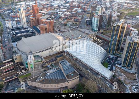 Aus der Vogelperspektive auf die AO Arena und das moderne lichtdurchlässige Dach der Victoria Station. Moderne Wohntürme rahmen den Verkehrsknotenpunkt. Stockfoto