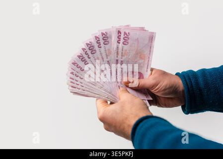 Mann hält türkische Lira-Banknoten in der Hand gefächert, Bargeldkonzept auf weißem Hintergrund. Hochwertige Fotos Stockfoto