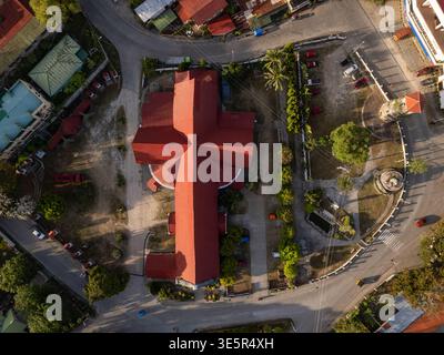 Siquijor, Philippinen – 11. April 2025: Ein Blick von oben nach unten zeigt das rote Dach der Pfarrkirche St. Francis von Assisi. Stockfoto
