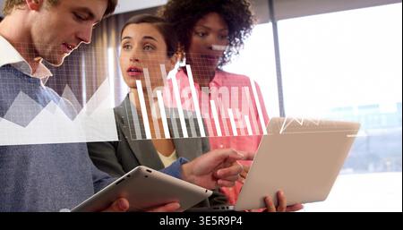 Analyse von drei Kollegen, die Notebooks und Tablets im Büro anzeigen und Diagramme in Business Casual anzeigen Stockfoto
