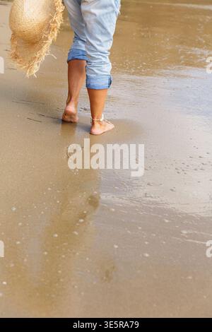 Nahaufnahme von Frauen barfuß am goldenen Strand mit Reflexion Stockfoto
