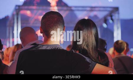 Paare sehen ein Live-Musikkonzert mit Publikum bei einem Festival-Abend im Freien Stockfoto