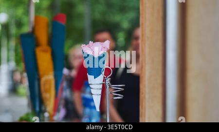 Pinkfarbenes Eis in blauem Waffelkegel, erfrischendes Sommerdessert Stockfoto