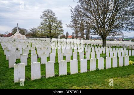 Ein bewegender Blick auf den Tyne-Cot-Friedhof in Flandern. Tausende von weißen Steingrabsteinen ehren die Gefallenen des Ersten Weltkriegs, mit dem Kreuz des Opfers hoch stehend Stockfoto