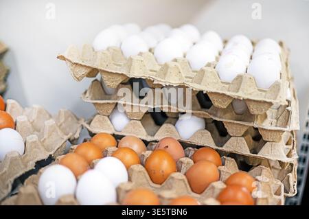 Hühnereier, weiß und braun, in einem Supermarkt übereinander gestapelt. Wirtschaftskrise. Ostern Stockfoto