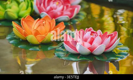 Bunte künstliche Lotusblüten, die in Vietnam auf dem Wasser schwimmen Stockfoto