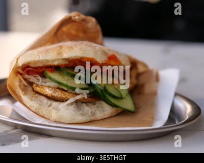 Nahaufnahme einer frischen vegetarischen Pita oder Döner-Kebab. Der Schuss sollte sich auf das knusprige, hausgemachte Fladenbrot konzentrieren, das mit lebhaften grünen Gurkenscheiben gefüllt ist Stockfoto