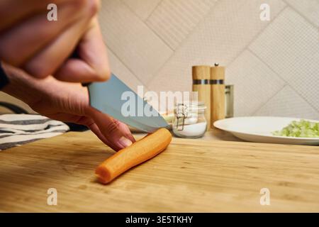Frau kitzt Karotte auf Schneidebrett, Nahaufnahme Stockfoto