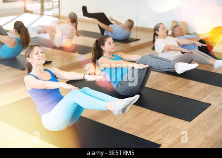 Junge Frau, die während des Aufwärmens im Pilates Studio V-SIT macht Stockfoto