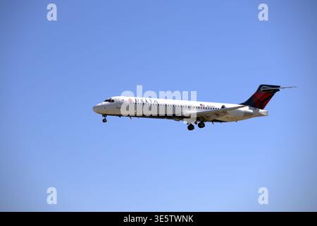 Delta Air Lines Boeing 717-200 Verkehrsflugzeug auf Endanflug zur Landung gegen einen klaren blauen Himmel mit klassischer Widgets-Lackierung. Stockfoto