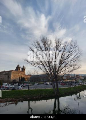Kontrastreiches Bild des Sonnenuntergangs hinter den Steinmauern des alten College in Monforte, das eine warme und friedliche Atmosphäre schafft. Stockfoto