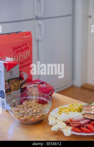 Jakkvik, Schweden - 28. Juli 2024: Ein herzhaftes Frühstück mit ICA Crunchy Müslimilch und einem vielfältigen Teller mit Protein und Gemüse in A Swedis Stockfoto
