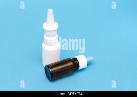 Flaschen mit Tropfen und Nasentropfen auf den Hintergrund sprühen. Medizin gegen Kälte Stockfoto
