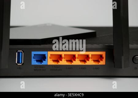 Rückseite des Netzwerk-Routers mit orangefarbenen Gigabit-ethernet-Ports, blauem wanlan-Port und usb-Anschluss, technische Details im Detail. Stockfoto