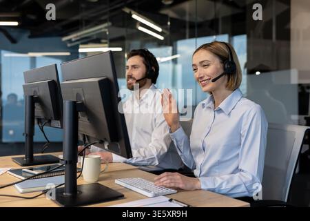 Kundendienstmitarbeiter, die Headsets tragen, unterstützen und kommunizieren Kunden in einer modernen Büroumgebung, wobei der Schwerpunkt auf effizientes Telemarketing und Unterstützung liegt Stockfoto