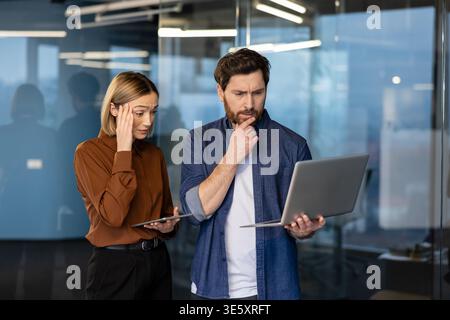 Mitarbeiter des Geschäftsteams haben Frustration und Sorgen bei der Analyse von Daten auf einem Laptop oder Tablet und kämpfen in einem modernen Büro mit einem herausfordernden technischen Problem oder einem Fehler Stockfoto