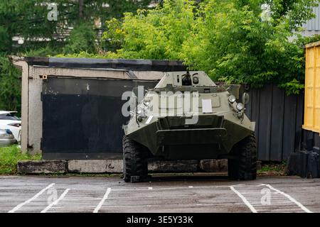 Gepanzertes Mannschaftstransportfahrzeug, militärisches Fahrzeug, geparkt in einer städtischen Garage, Frontansicht mit grünem Tarnmuster Stockfoto