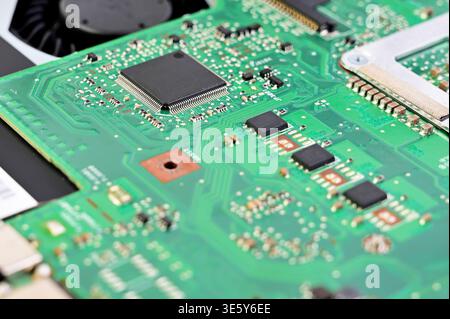 Nahaufnahme einer komplexen grünen Leiterplatte mit integrierten Chips und Komponenten Stockfoto