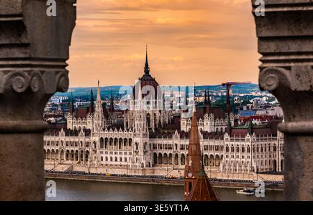 Fantastischer Blick auf das ungarische Parlament bei Sonnenuntergang in Budapest durch die Bögen der Fischerbastei Stockfoto