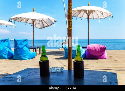 Tisch mit zwei Flaschen Bier, Bali, Indonesien, Südostasien. Tisch mit zwei Flaschen Bier und Blick auf das Meer, Bali, Indonesien. Stockfoto