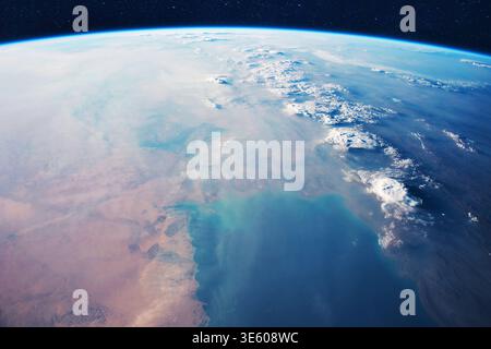 Atemberaubender filmischer Blick auf die Erde aus dem All, der die Krümmung des Planeten, die dünne blaue Atmosphäre und die wirbelnden weißen Wolken über einem weiten Wüstengelände zeigt Stockfoto