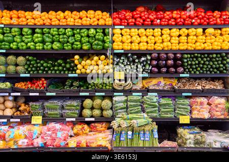 Auswahl an frischem Bio-Gemüse in Supermarktregalen. Farbenfrohe Ausstellung von Paprika, Gurken und Gemüse in einem Lebensmittelgeschäft. Stockfoto