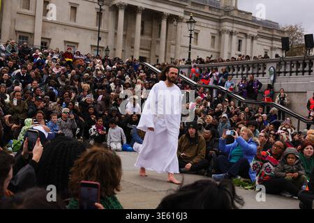 London, UK . April 2026. Jesus steigt aus den Menschenmassen vor der National Gallery für die jährliche Nachstellung des biblischen Stücks von Wintershall auf. Die Menschenmassen sitzen eng zusammen, während ein Darsteller Jesus während einer immersiven Passion of Christ-Performance am Trafalgar Square darstellt. Eine moderne Nacherzählung der Passion Christi entfaltet sich unter den Zuschauern auf dem Trafalgar Square, die Theater und öffentlichen Raum bei Osterveranstaltungen miteinander verbindet. Quelle: Desislava Lizova/Alamy Live News Stockfoto