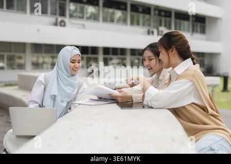 Eine Gruppe verschiedener Universitätsstudenten, die an Studiengängen im Freien teilnahmen, Notizen teilten und Ideen an einem Campus-Tisch diskutierten Stockfoto
