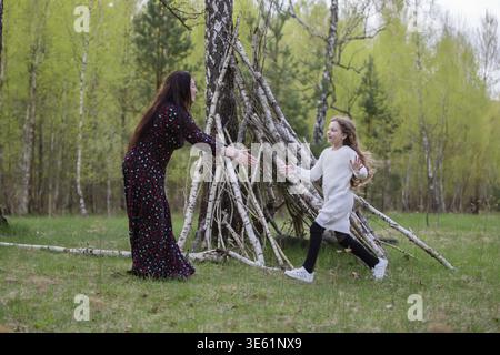 Mom und Tochter spielen in einem Birkenhain und unterhalten sich gerne miteinander Stockfoto