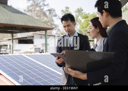 Ein Team aus verschiedenen Fachleuten konzentriert sich auf Solarlösungen, diskutiert ihre nachhaltigen Geschäftsstrategien im Außenbereich und fördert die Zusammenarbeit Stockfoto