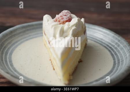 Ein kleiner japanischer Erdbeer-Shortcake auf einem stilvollen japanischen Teller auf einer braunen Holzterrasse Stockfoto