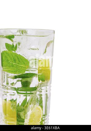 Essen, Ein hohes Glas enthält ein erfrischendes Getränk gefüllt mit Minzblättern und Limettenscheiben. Kondensattröpfchen zieren das Glas, was auf einen kühlen Biber hinweist Stockfoto