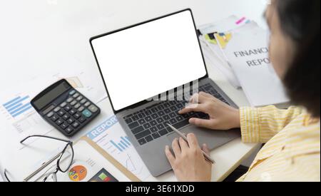 Ein Buchhalter arbeitet mit einem Laptop und Taschenrechner, umgeben von Dokumenten, an Finanzberichten. Schwerpunkt auf Finanzanalyse und Berichterstattung Stockfoto