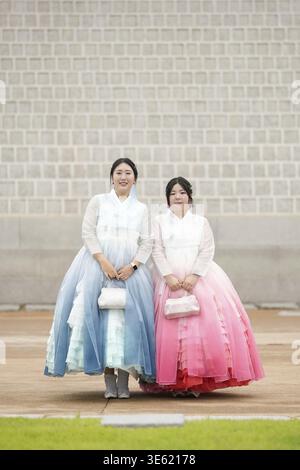 Im Juni 2025 posierte eine Koreanerin im Alter von 20 Jahren in einem bezaubernden rosafarbenen Hanbok für ein Erinnerungsfoto vor der Steinmauer von Gye Stockfoto