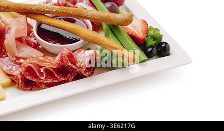 Speisen, Eine farbenfrohe Platte mit einer Vielzahl von Wurstwaren, Käse, frischem Gemüse und Obst, perfekt für eine leichte Mahlzeit oder Vorspeise. Das ist lebendig Stockfoto